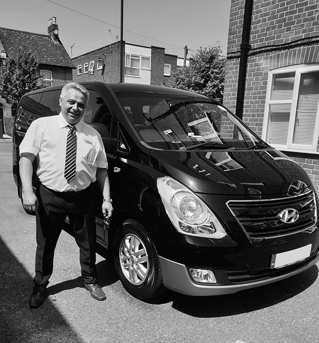 London Limousines & Shuttles owner, Kriss, standing beside one of his shuttles.